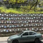 Memorial wall in Comuna 13 Medellín with portraits of victims, representing remembrance and resilience.